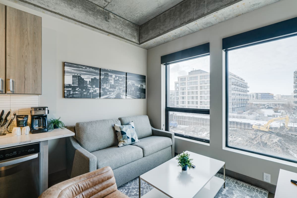 Unwind in your stylish living space with floor-to-ceiling windows, modern furnishings, and a fully equipped kitchen for your urban getaway.
