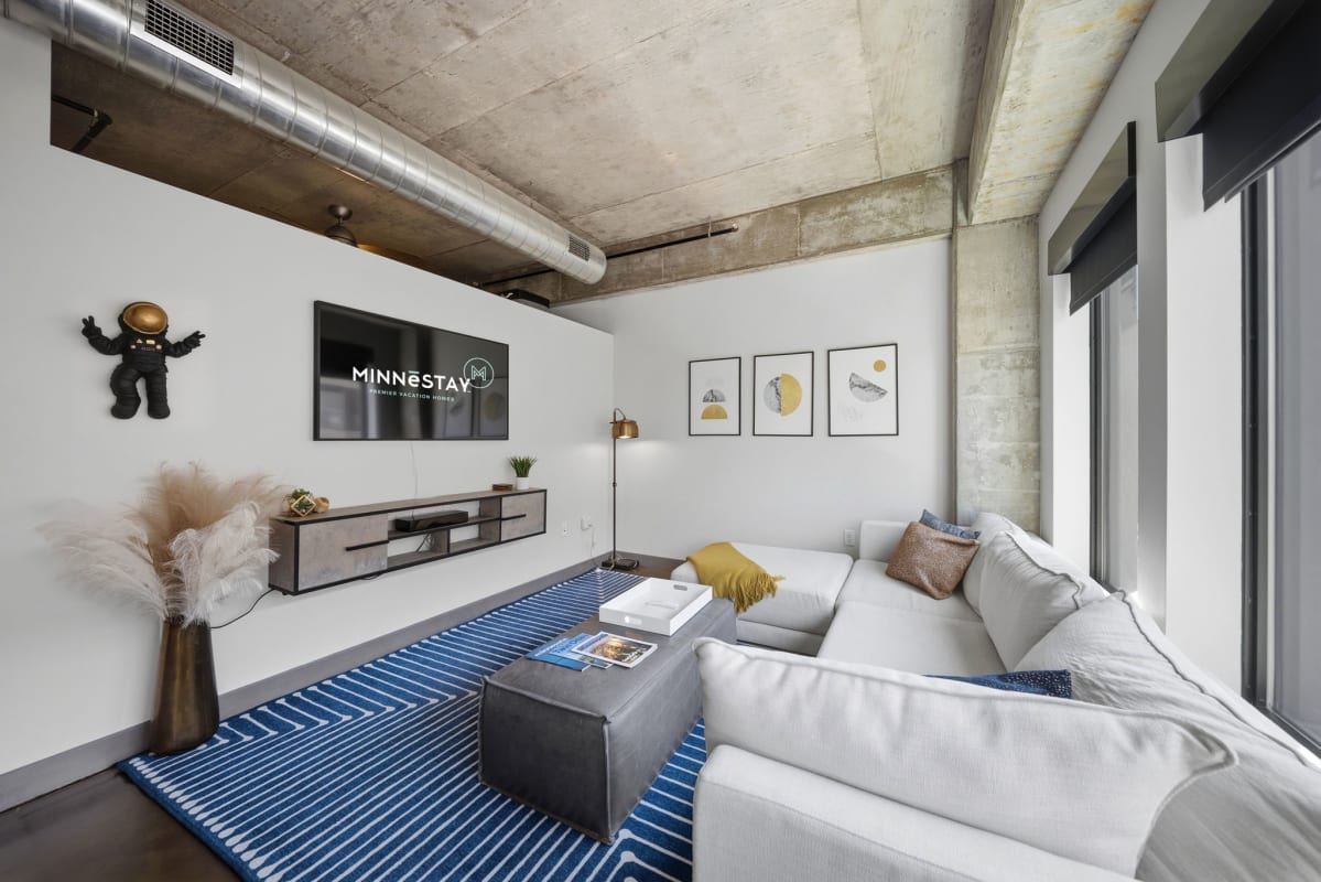 Sink into plush sofas in your modern living room, where industrial-chic concrete meets cozy comfort. Unwind with a movie on the large TV or relax with your favorite book in this stylish, light-filled retreat.