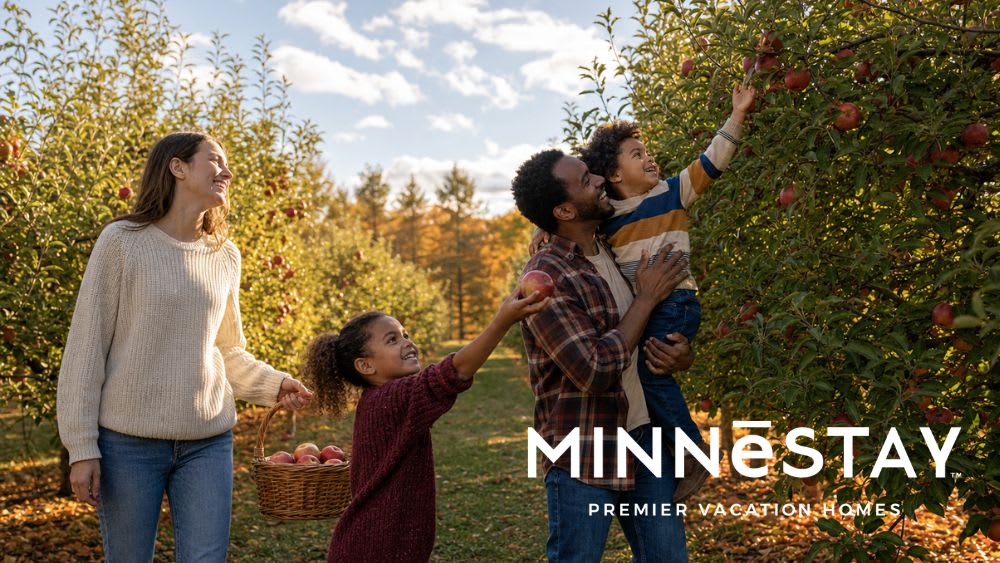 A family picking red apples together in a Minnesota orchard.