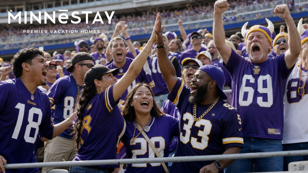 Minnesota Vikings fans cheering together in the stadium stands.