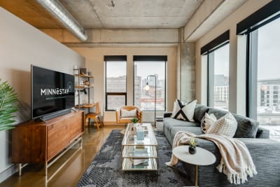 Modern living room featuring large windows, contemporary furniture, and city views.