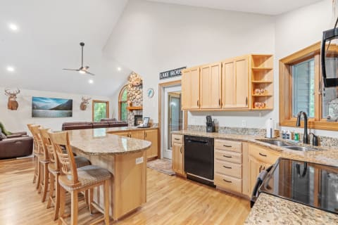 Modern kitchen in a lake house featuring granite countertops and rustic decor.