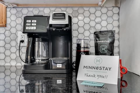 A coffee station featuring a Hamilton Beach coffee maker, a bag of coffee, and a note that says 'Thank you!!'
