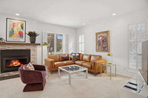 Cozy living room with leather couches and a stone fireplace.