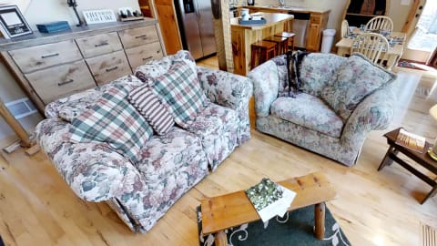 Cozy living room featuring floral-patterned sofas and wooden accents.