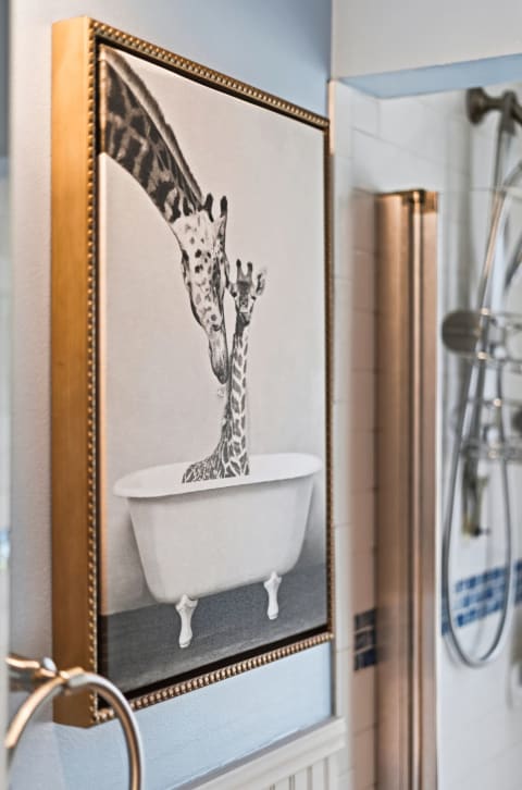 Art featuring two giraffes in a white bathtub in a bathroom setting.