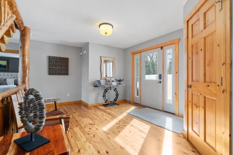 Interior view of a cozy entryway featuring wooden furniture and natural light.