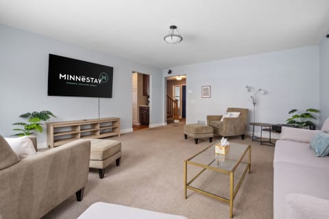 Bright living room featuring a television screen and comfortable furniture.