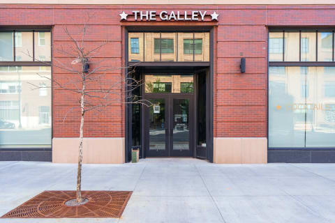 The entrance of The Galley featuring modern architecture with a brick facade and glass doors.