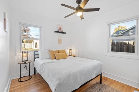 Cozy bedroom with a queen-sized bed, modern decor, and natural light.