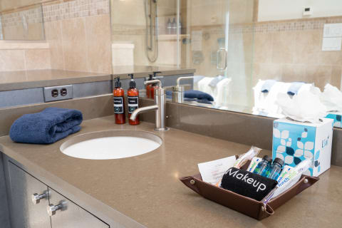 Modern bathroom vanity with a round sink and toiletries.