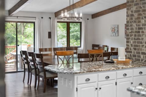 A spacious dining area with a wooden table, chairs, and sliding glass doors leading to a deck.