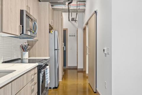 Modern kitchen with wooden cabinetry and stainless steel appliances.