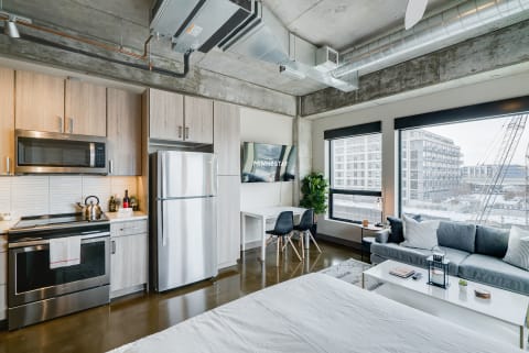 A modern studio apartment with a kitchen and a cozy living area.