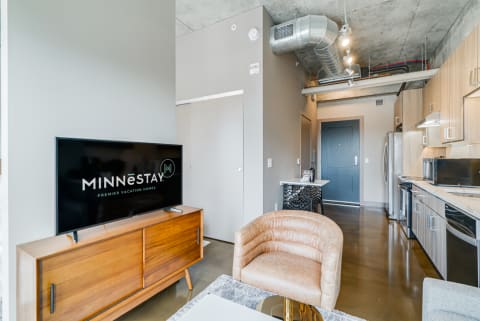 Interior view of a contemporary vacation rental living space with a TV and kitchen area.