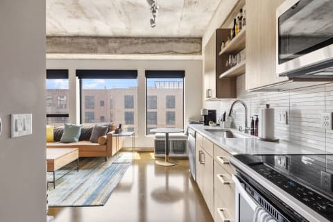 Interior of a modern studio apartment with a kitchen and living area.