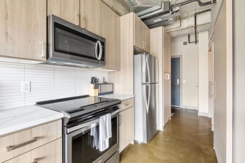 A contemporary kitchen showcasing wooden cabinetry and modern appliances.