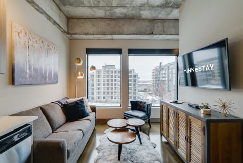 Contemporary living room with a gray sofa, coffee table, and wall-mounted TV.