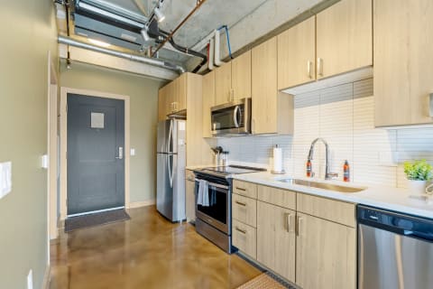 Modern kitchen with wooden cabinets and polished countertops.