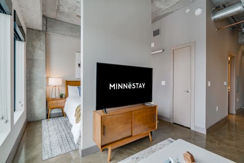 Interior view of a modern studio apartment showcasing a TV and bedroom area.