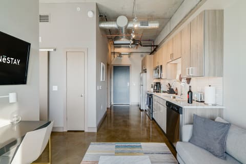 Modern apartment interior with a kitchen, living area, and sleek furnishings.