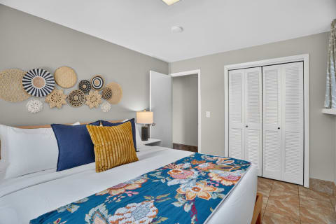 A cozy bedroom with a large bed, decorative wall baskets, and a warm color palette.