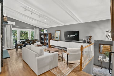 A light-filled open living space with hardwood floors, modern furniture, and stylish decor.
