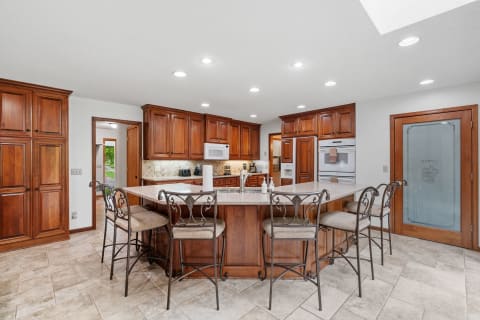 A contemporary kitchen with rich cabinets, a central island, and stylish seating.