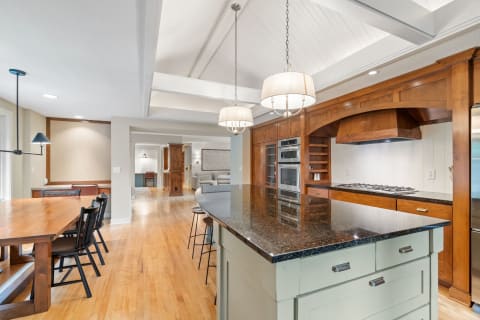 Stylish kitchen with granite countertops, wooden cabinetry, and a dining area.