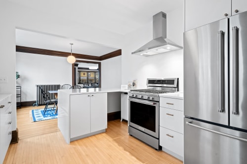 Your spacious kitchen features modern stainless appliances, sleek white cabinetry, and warm hardwood floors for culinary adventures.