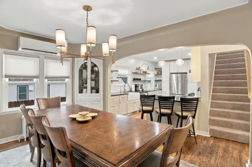 Gather around your beautiful dining table beneath warm lighting, with direct sightlines into your fully equipped kitchen.