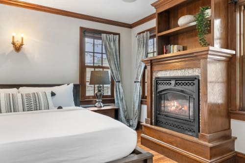Unwind in your cozy bedroom sanctuary where rich wood details and a crackling fireplace create the perfect atmosphere for restful nights.