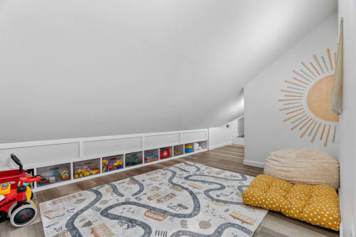 Your little ones will love this cozy attic play space, complete with toy storage and soft floor cushions for endless adventures.