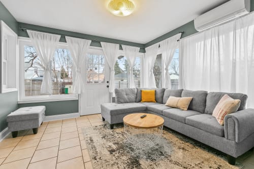 Settle into your bright, airy sunroom where floor-to-ceiling windows flood the space with natural light.