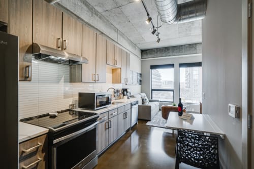 Your modern kitchen features sleek appliances and city views, perfect for preparing meals while enjoying urban scenery.