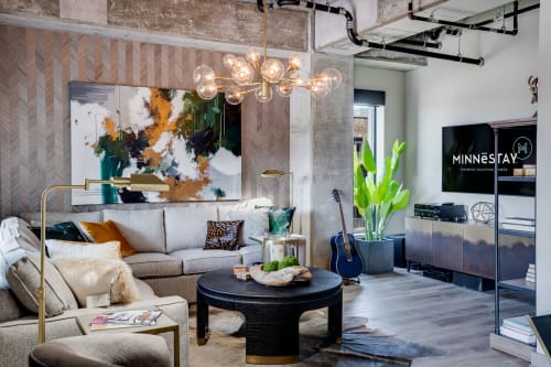Unwind in this stylish living room where modern art meets cozy comfort, complete with plush seating and contemporary lighting.