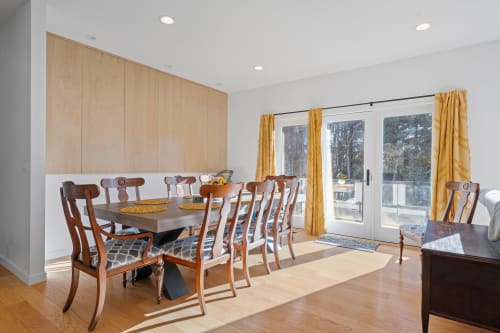 Gather your group around this elegant dining table, where warm wood tones and golden curtains create the perfect setting for memorable meals together.