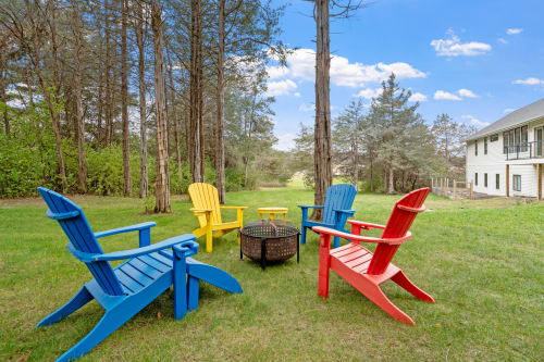 Gather around the fire pit in colorful Adirondack chairs, where your evenings transform into memorable conversations under the open sky.